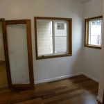 Interior shot of wood trimmed windows and doorways with new wooden flooring