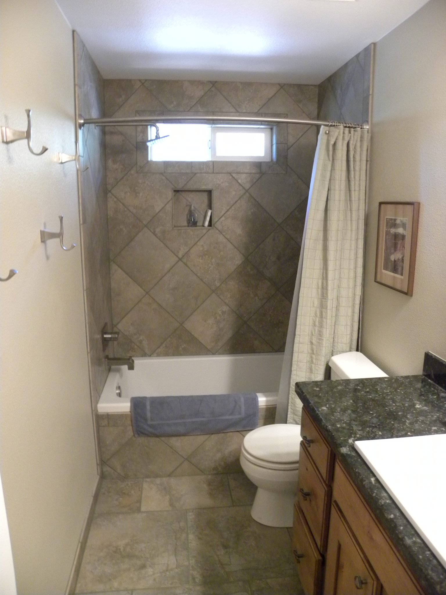 Interior shot of a custom designed bathroom with gray tiling and granite countertops