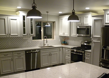 Kitchen Renovation Flagstaff with Hanging & Recessed Lights, White Cabinets, and Light Color Counters