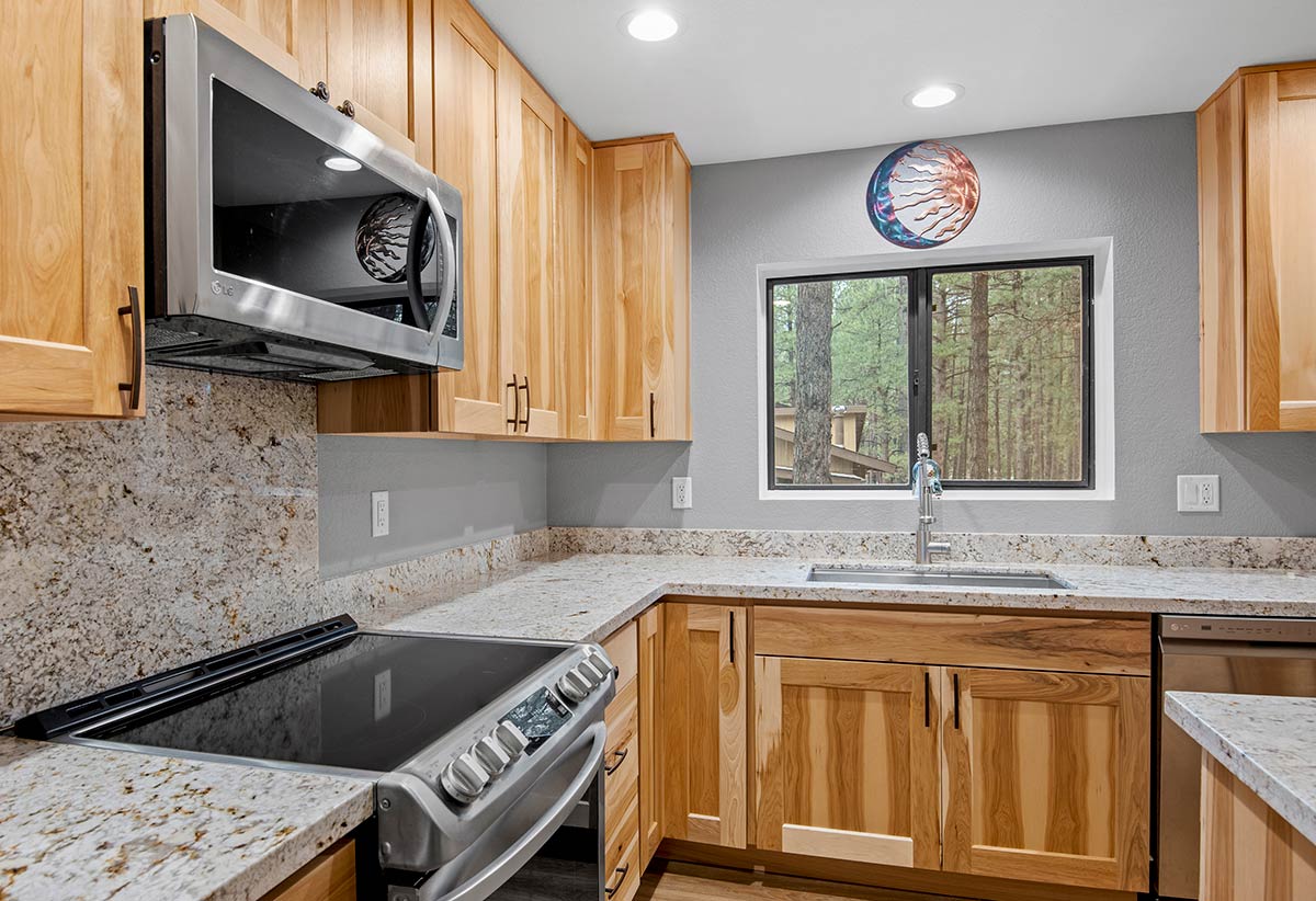 Remodeled Kitchen With Granite Counters and Wooden Cabinetry