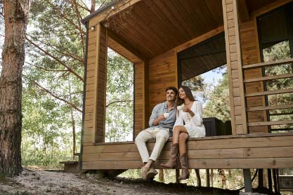 Couple Sipping Coffee Sitting on Wood Deck