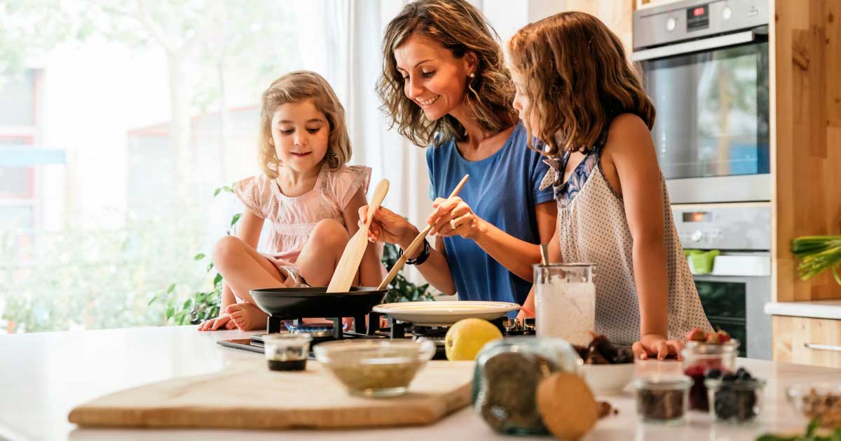 Mother and Daughters in Kitchen Cooking Meal