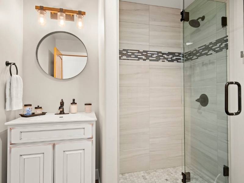 small bathroom with white vanity and glass walk in shower