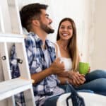 Young husband and wife sitting in a room taking a break from painting