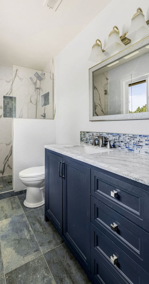 Newly remodeled bathroom with storage compartment and drawers finished in blue