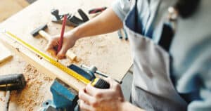 Quality Craftsmanship Wood expert carefully measuring a cut with tape measure and pencil