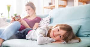 Smart & Sustainable Upgrades Mom reading book and daughter laying out on couch inside hom