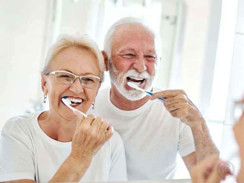 older couple brushing their teeth in a remodeled bathroom